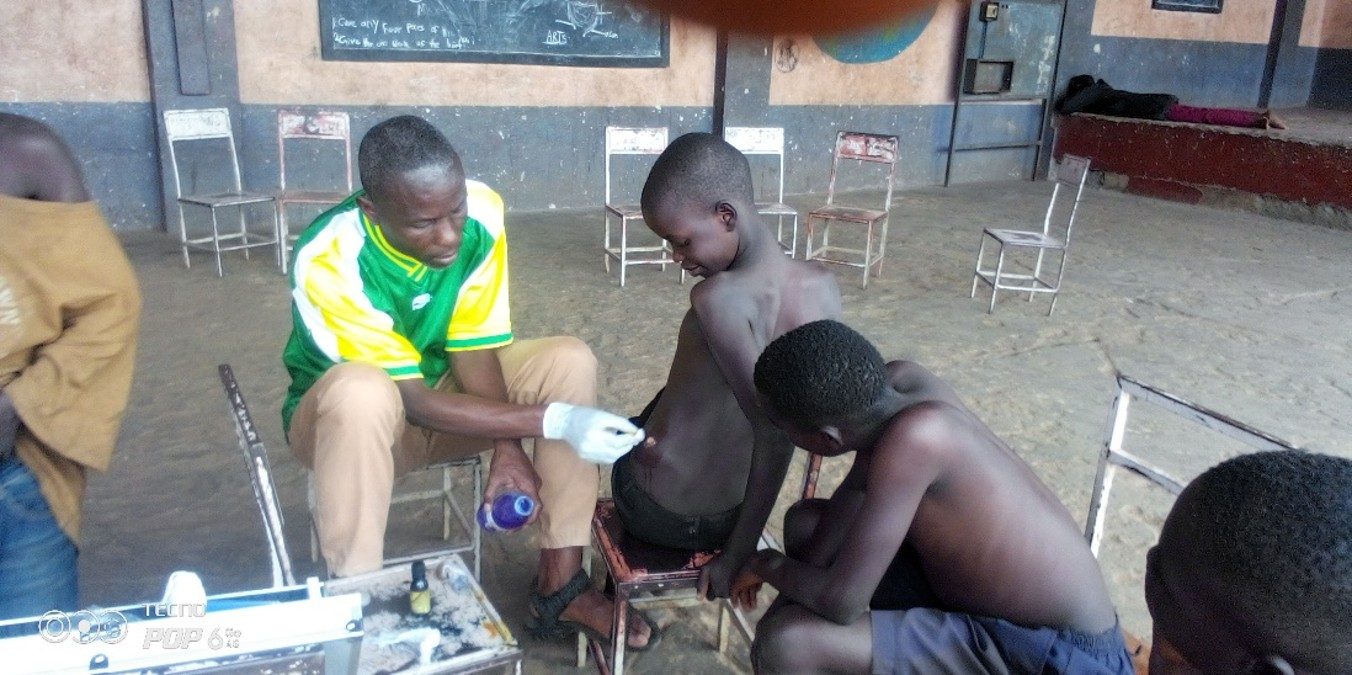 A Child Restoration Outreach Uganda health worker providing medical support to a child
